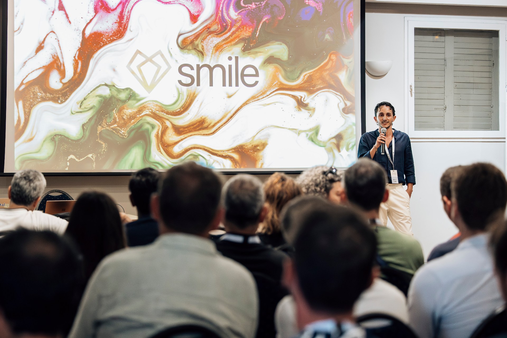 Conférence Smile Academy — intervenant avec micro devant un auditoire