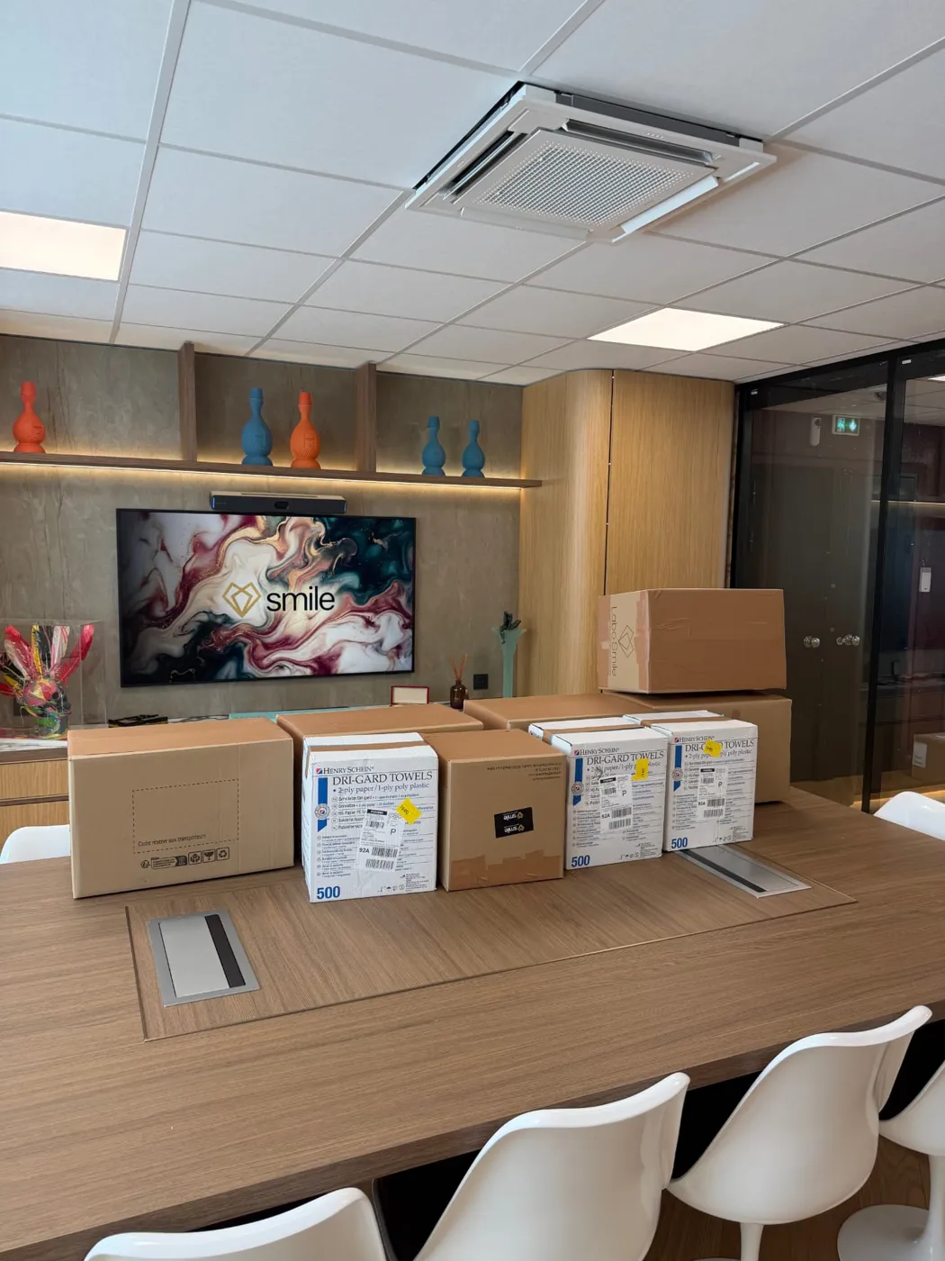 Cartons LaboSmile et Henry Schein prêts à l'envoi dans la salle de réunion Smile